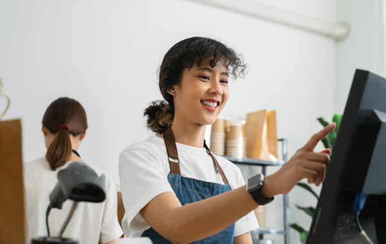 News &Amp; Updates 25 Woman Cashier Wears An Apron And Using Pos Termina 2023 01 27 02 08 10 Utc